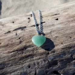 collier en aventurine posé sur du bois flotté