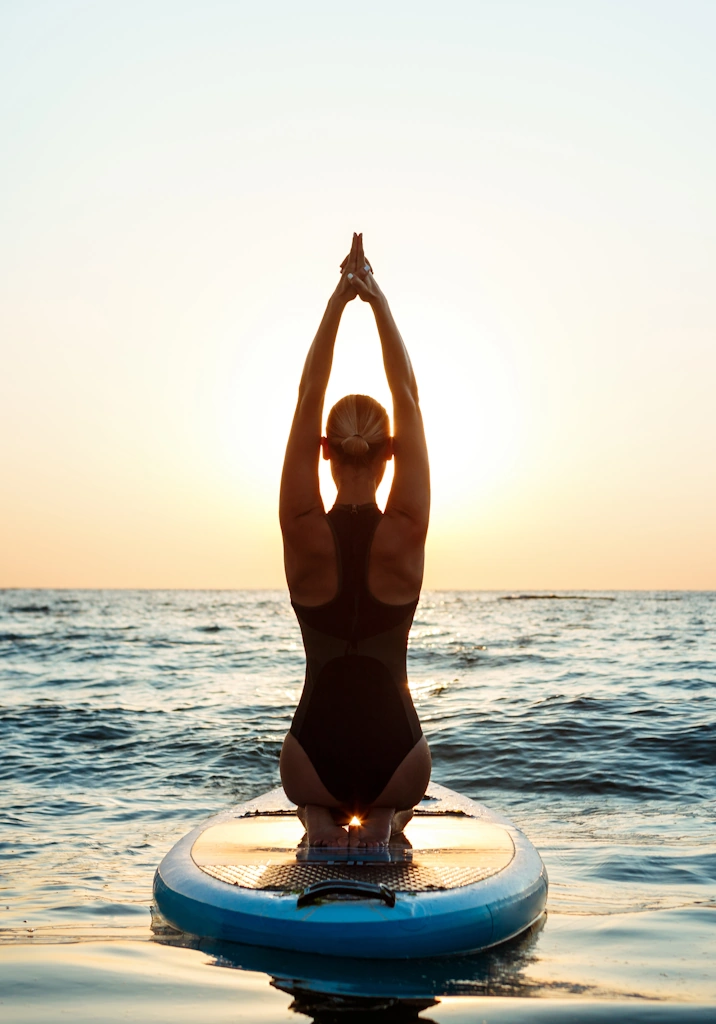 femme faisant du yoga sur une planche