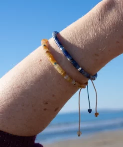 mixe de bracelet en aventurine jaune et bracelet en sodalite sur vue mer