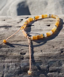 lithothérapie, bracelet en aventurine jaune posé sur bois flotté