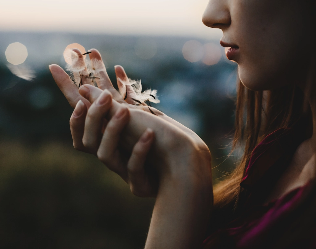 femme qui souffle sur des fleures