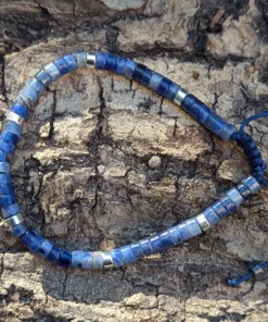 zoom sur un bracelet en sodalite posé sur une buche de bois