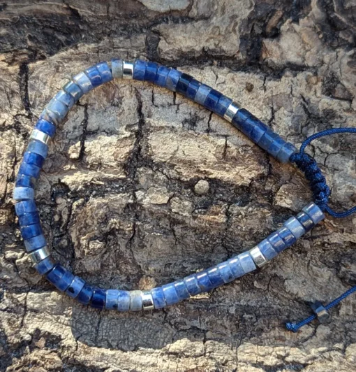 zoom sur un bracelet en sodalite posé sur une buche de bois