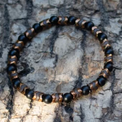 bracelet onyx et hématite posé sur du bois flotté