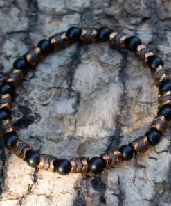 bracelet onyx et hématite posé sur du bois flotté