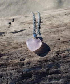 collier en quartz rose, posé sur du bois flotté